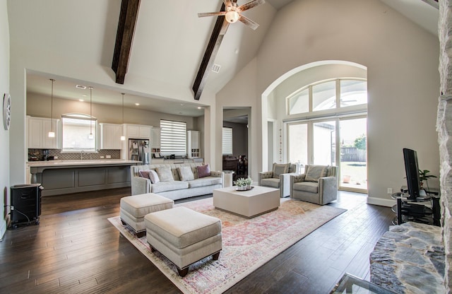 living area featuring dark wood-style flooring, a wealth of natural light, high vaulted ceiling, and a ceiling fan
