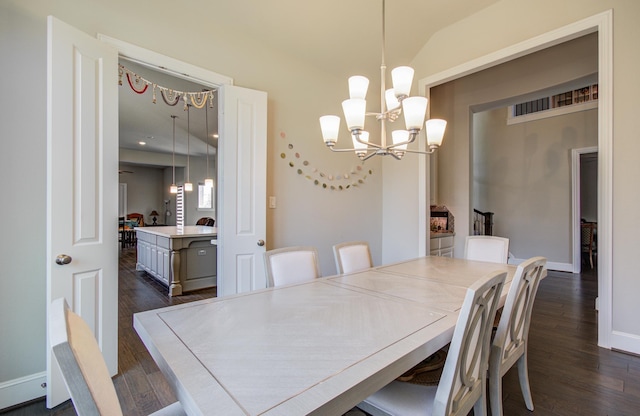 dining space with a chandelier, dark wood-style floors, baseboards, and vaulted ceiling