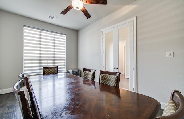 dining room featuring visible vents, baseboards, wood finished floors, and ceiling fan