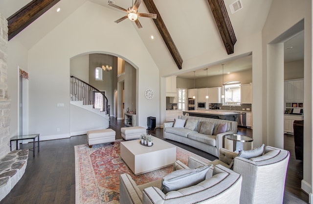 living room featuring dark wood-style floors, visible vents, beam ceiling, high vaulted ceiling, and arched walkways