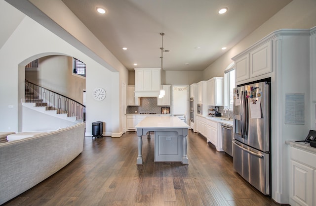 kitchen with stainless steel appliances, dark wood-type flooring, light countertops, and backsplash