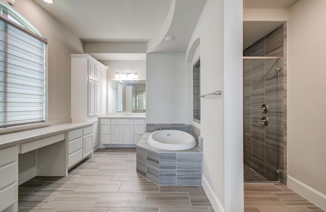 full bath with vanity, wood finish floors, a bath, and a stall shower