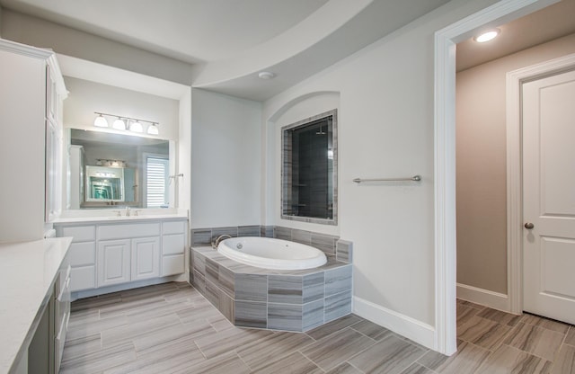 bathroom with a bath, vanity, baseboards, and wood tiled floor