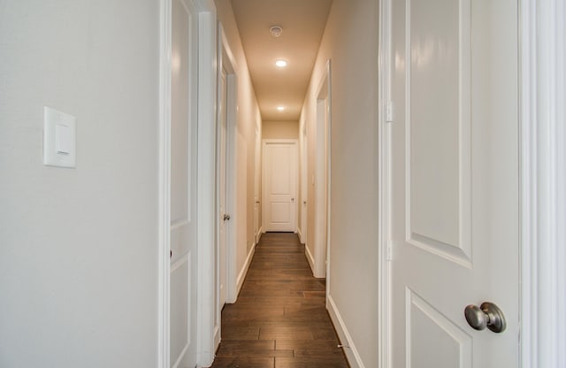 corridor with baseboards and dark wood-style floors
