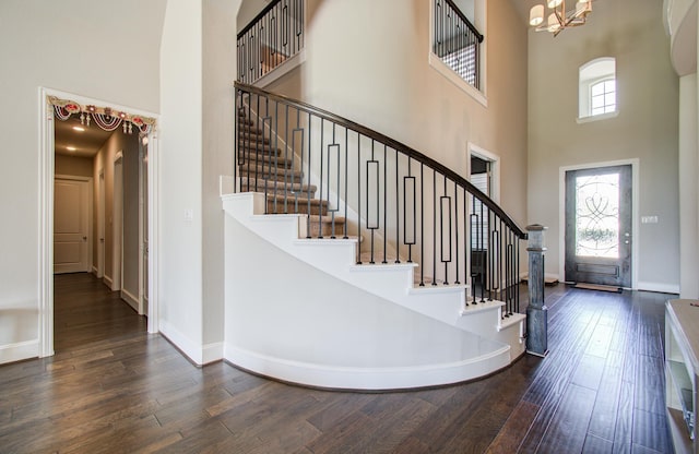 entrance foyer with wood finished floors, a notable chandelier, and stairs