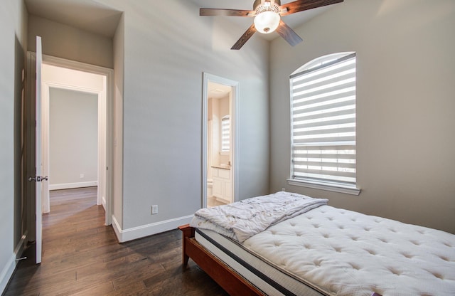 bedroom with dark wood-style flooring, baseboards, and ensuite bathroom