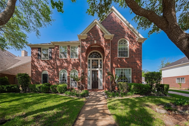 view of front facade featuring a front yard and brick siding