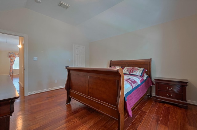 bedroom with visible vents, baseboards, wood finished floors, and lofted ceiling