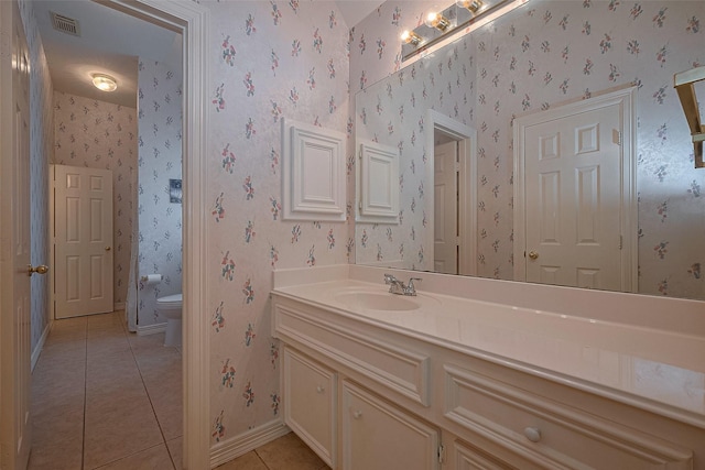 bathroom with vanity, baseboards, tile patterned floors, toilet, and visible vents