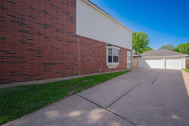 view of side of home featuring a detached garage, an outdoor structure, and brick siding