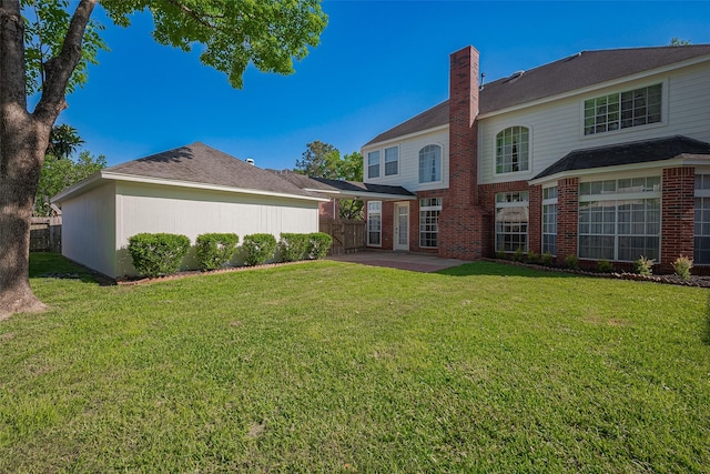 rear view of property with a patio area, a chimney, fence, and a lawn