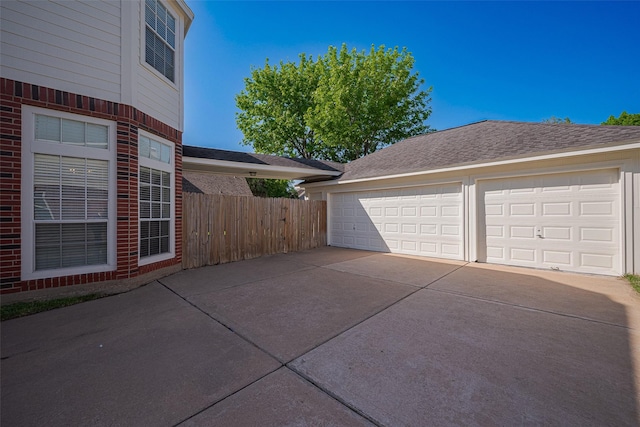 detached garage featuring fence
