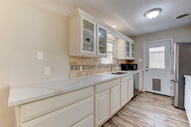 4103 Donna Lynn Dr, Houston, TX 77092 - kitchen with backsplash, light wood-style floors, visible vents, stainless steel appliances, and a sink