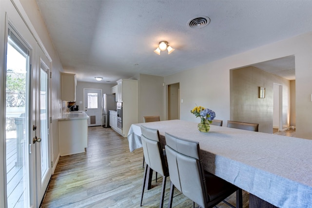 4103 Donna Lynn Dr, Houston, TX 77092 - dining space featuring visible vents, light wood-style flooring, and a textured ceiling