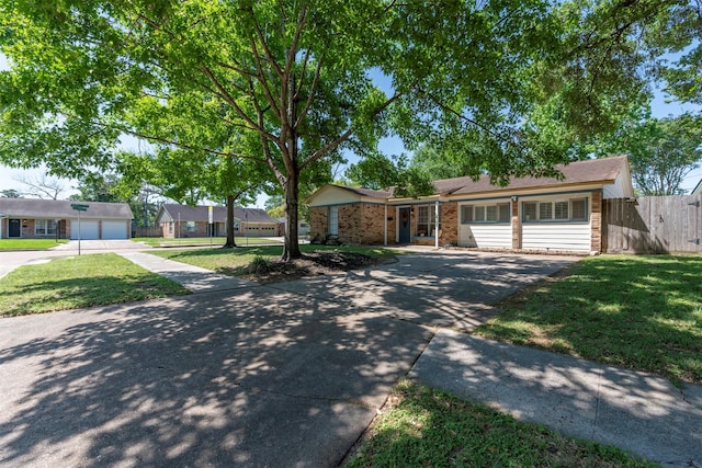 4103 Donna Lynn Dr, Houston, TX 77092 - ranch-style home with aphalt driveway, brick siding, fence, and a front lawn