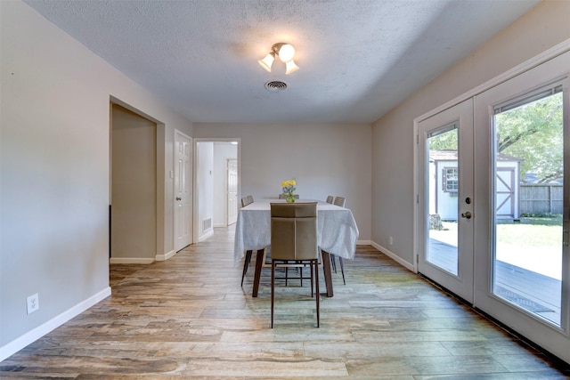 4103 Donna Lynn Dr, Houston, TX 77092 - dining room with french doors, visible vents, light wood-style floors, and a textured ceiling
