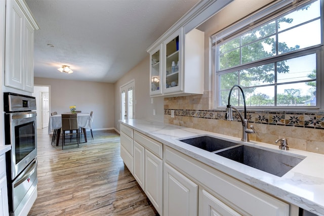 4103 Donna Lynn Dr, Houston, TX 77092 - kitchen with tasteful backsplash, light wood-style flooring, a warming drawer, stainless steel oven, and a sink