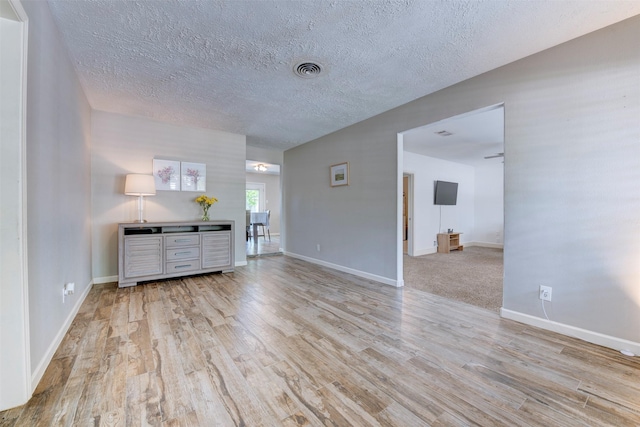 4103 Donna Lynn Dr, Houston, TX 77092 - unfurnished living room with visible vents, baseboards, wood finished floors, and a textured ceiling