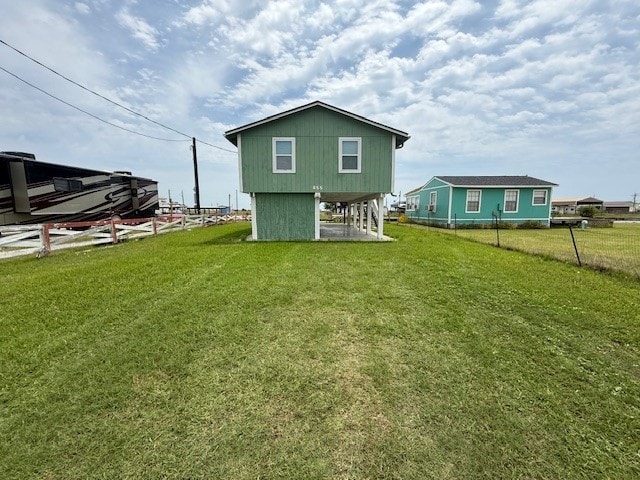 rear view of house with fence and a lawn
