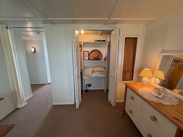 hallway with dark colored carpet