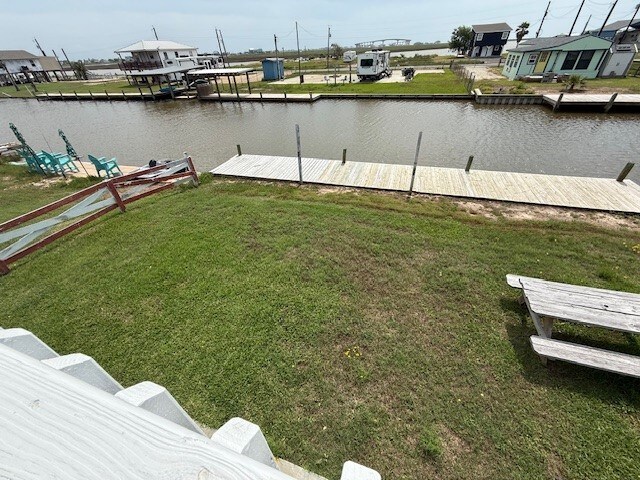 view of yard with a water view and a boat dock