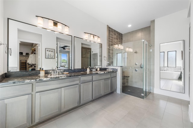 full bath with a shower stall, a sink, a freestanding bath, tile patterned floors, and double vanity