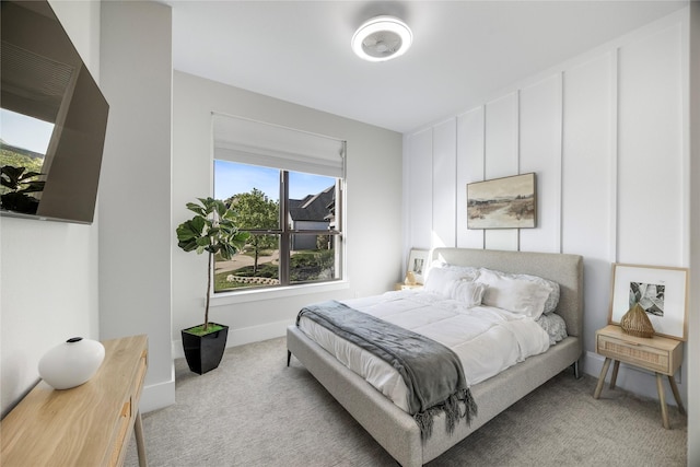 bedroom with baseboards and light carpet