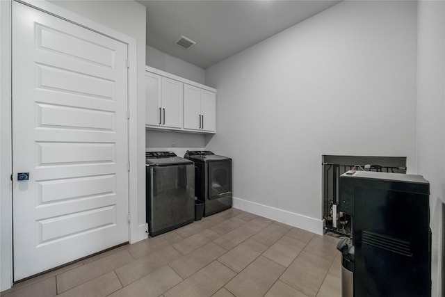 clothes washing area with cabinet space, visible vents, independent washer and dryer, and baseboards