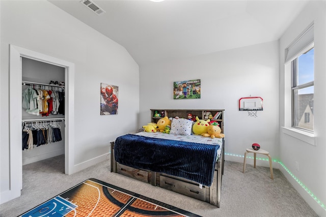 bedroom featuring baseboards, a spacious closet, carpet floors, visible vents, and lofted ceiling