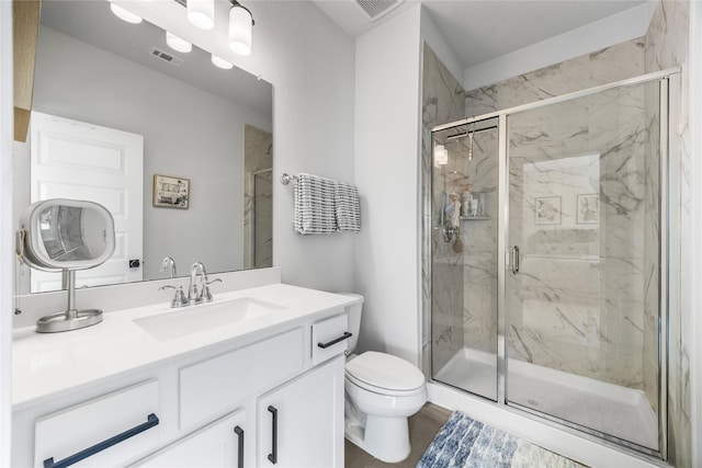full bath with toilet, vanity, visible vents, and a marble finish shower