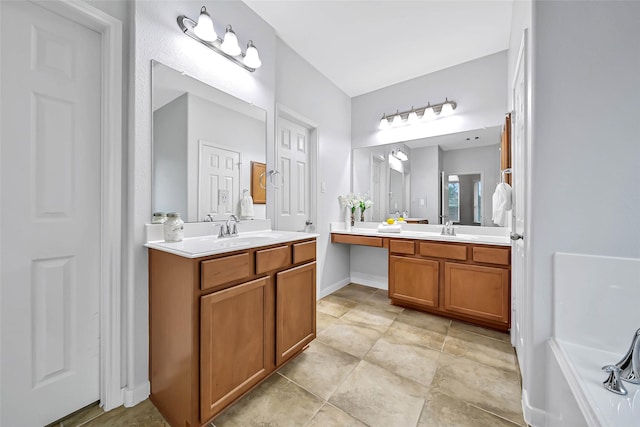 full bathroom with two vanities, a sink, and baseboards