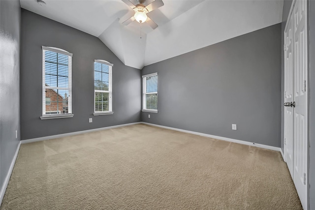 unfurnished room featuring light colored carpet, baseboards, a ceiling fan, and lofted ceiling