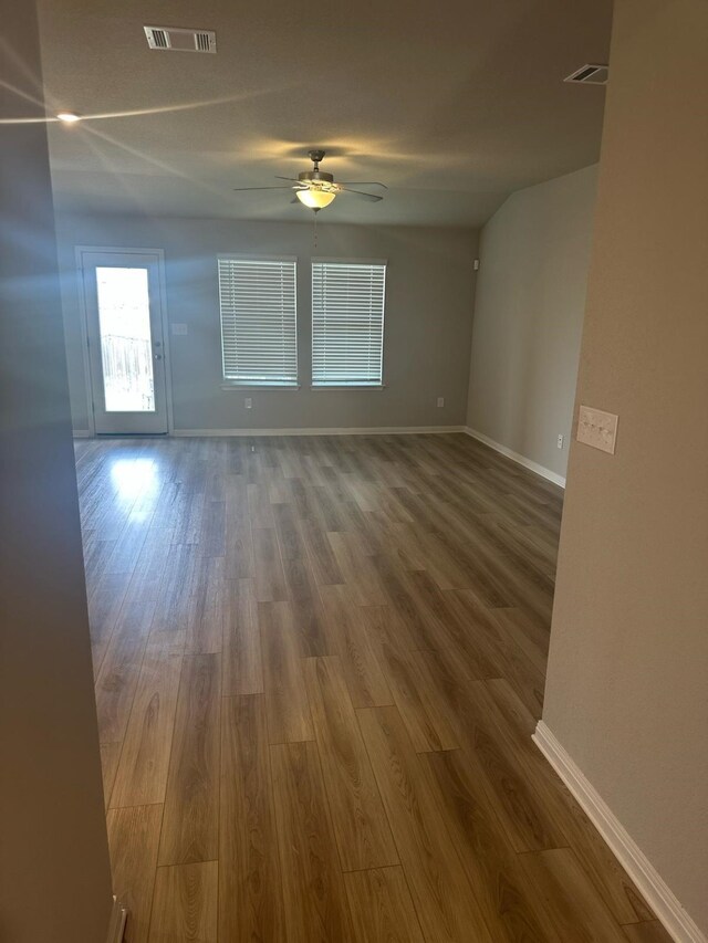 14020 Heartland Dr, Manor, TX 78653 - unfurnished room featuring visible vents, baseboards, a ceiling fan, and wood finished floors