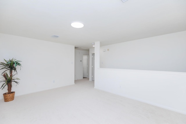 spare room featuring light carpet and visible vents