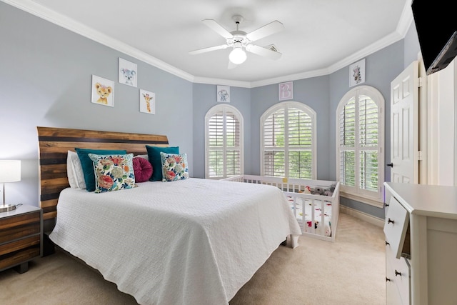 bedroom with baseboards, light colored carpet, crown molding, and a ceiling fan