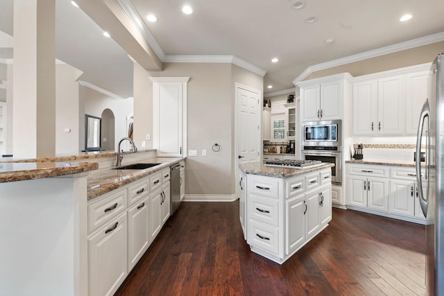 kitchen featuring light stone counters, a sink, dark wood finished floors, and stainless steel appliances