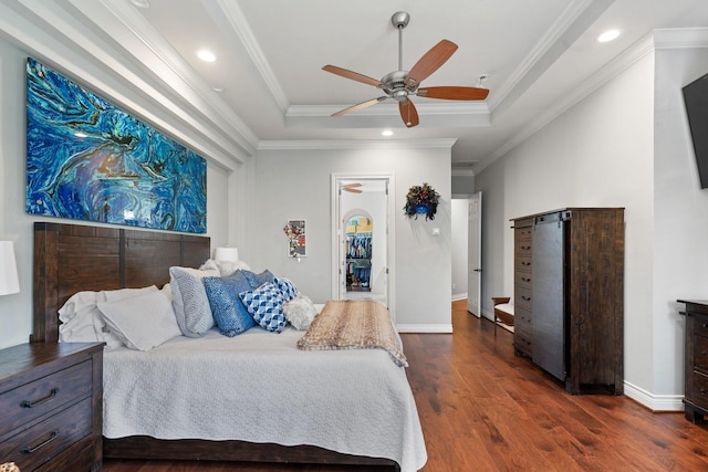 bedroom featuring a raised ceiling, ornamental molding, dark wood finished floors, and recessed lighting