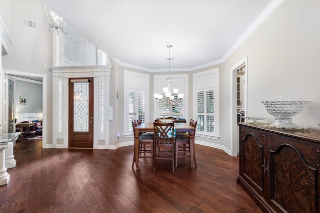 dining space with visible vents, baseboards, a notable chandelier, dark wood finished floors, and crown molding