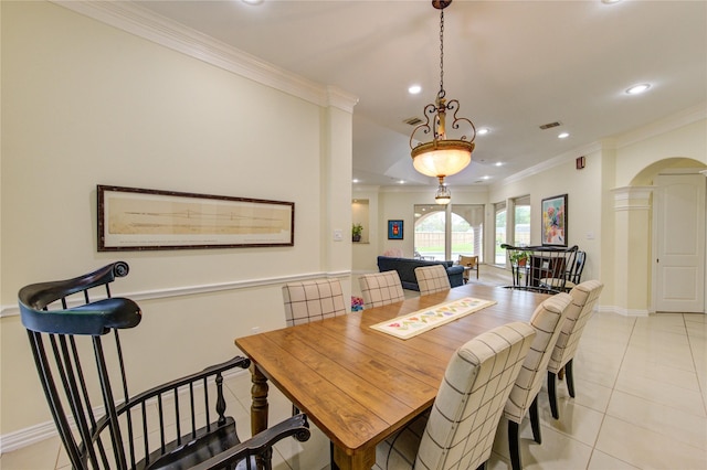 dining area featuring arched walkways, light tile patterned floors, ornamental molding, and recessed lighting