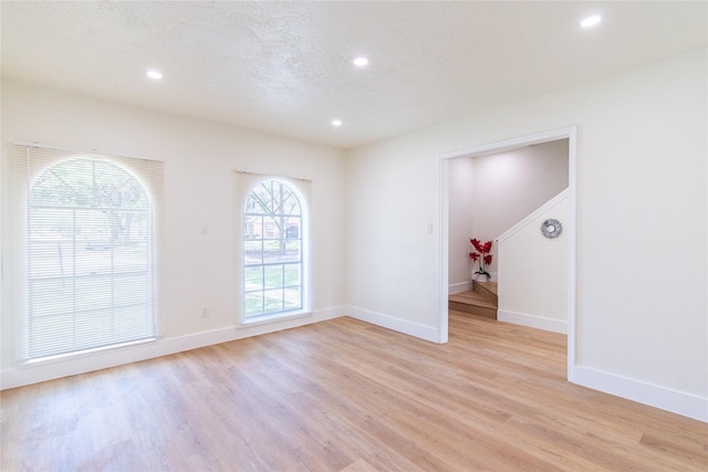 empty room with recessed lighting, baseboards, and light wood-type flooring