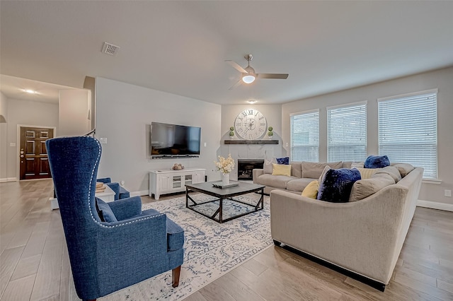 26626 Yukon Straight Dr, Richmond, TX 77406 - living room featuring a fireplace, visible vents, wood finished floors, and ceiling fan