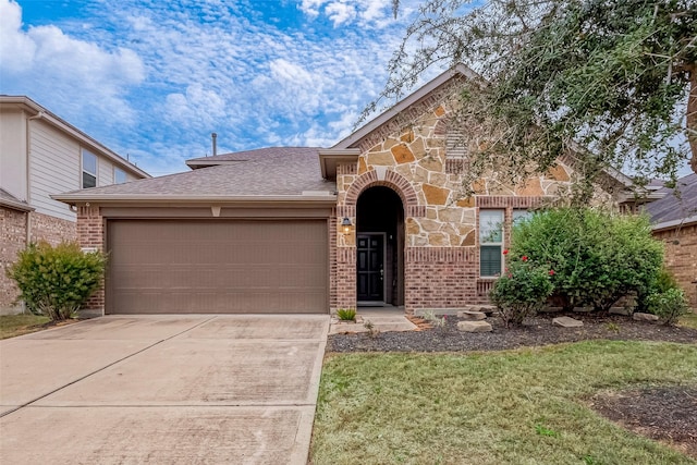 26626 Yukon Straight Dr, Richmond, TX 77406 - view of front of house featuring a garage, stone siding, driveway, and brick siding
