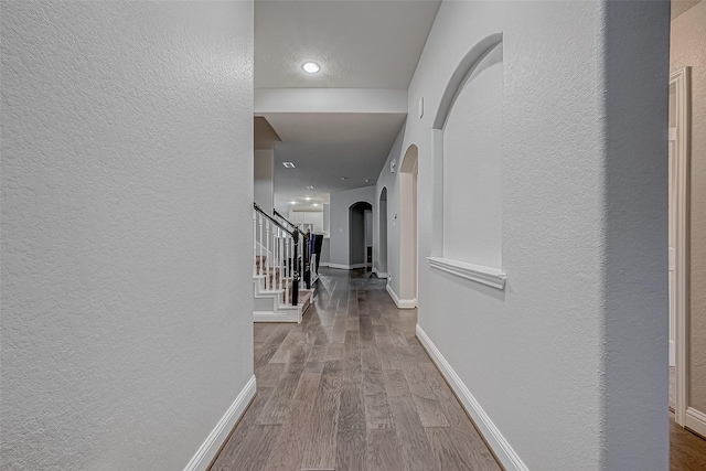 26626 Yukon Straight Dr, Richmond, TX 77406 - corridor with arched walkways, stairway, baseboards, and wood finished floors