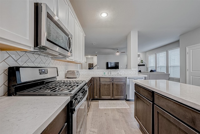 26626 Yukon Straight Dr, Richmond, TX 77406 - kitchen with stainless steel appliances, dark brown cabinetry, a ceiling fan, and backsplash