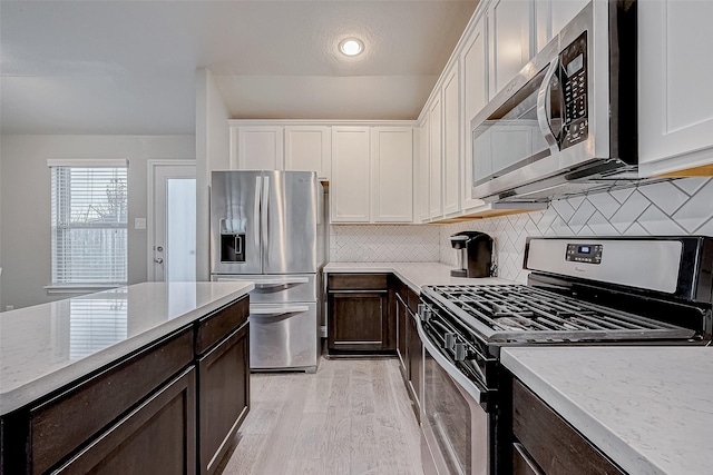 26626 Yukon Straight Dr, Richmond, TX 77406 - kitchen with white cabinets, dark brown cabinets, and appliances with stainless steel finishes