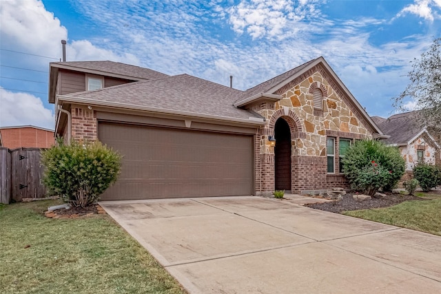 26626 Yukon Straight Dr, Richmond, TX 77406 - view of front of property featuring concrete driveway, stone siding, brick siding, a garage, and fence