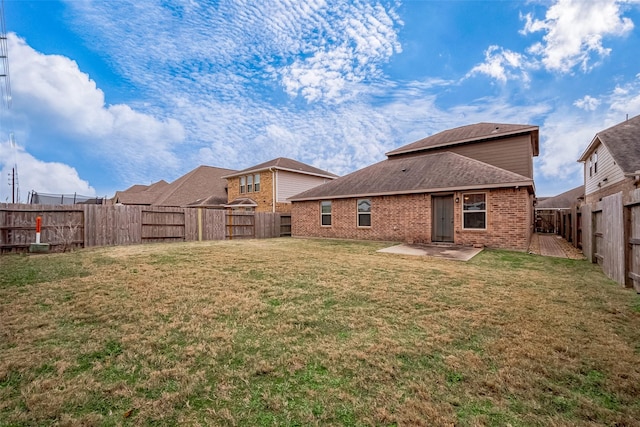 26626 Yukon Straight Dr, Richmond, TX 77406 - rear view of house with roof with shingles, a patio area, brick siding, a fenced backyard, and a lawn