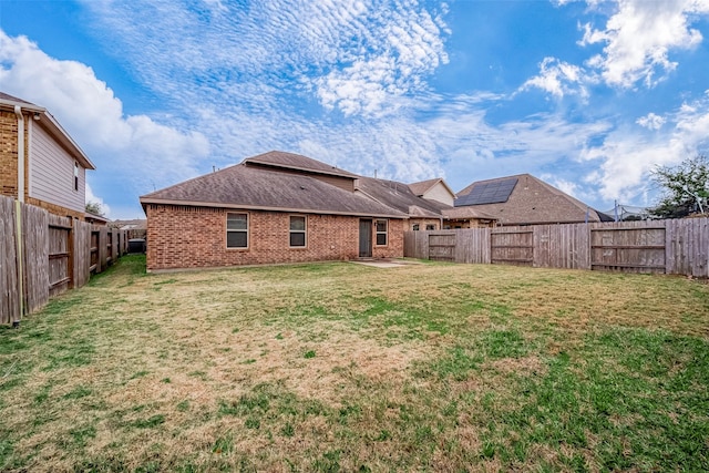 26626 Yukon Straight Dr, Richmond, TX 77406 - rear view of property featuring roof with shingles, brick siding, a fenced backyard, and a lawn