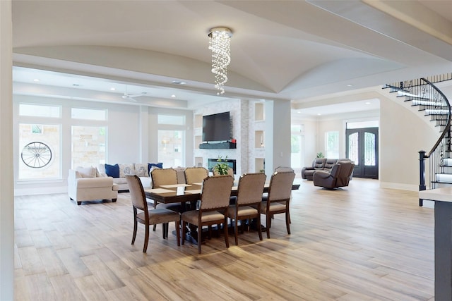 dining space with baseboards, light wood-style flooring, a wealth of natural light, and stairway