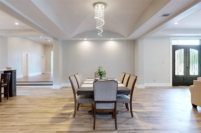 dining space featuring visible vents, light wood finished floors, baseboards, and an inviting chandelier